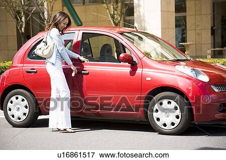 Young woman locking car door View Large Photo Image Stock Photo - Young woman locking car door. Fotosearch