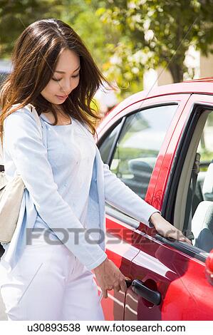 Young woman unlocking car door View Large Photo Image Stock Photo - Young woman unlocking car door. Fotosearch