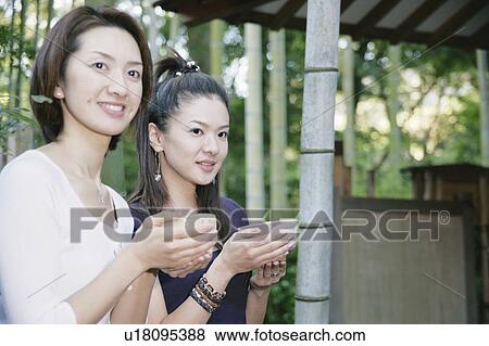 Stock Photo - Two young women drinking green tea. Fotosearch