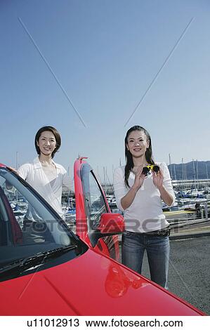 Two young women getting out of car by marina View Large Photo Image Stock Image - Two young women getting out of car by marina. Fotosearch
