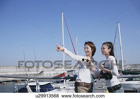 Stock Photo - Two young women in marina. Fotosearch