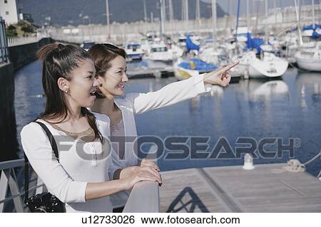 Stock Photograph - Two young women in marina. Fotosearch