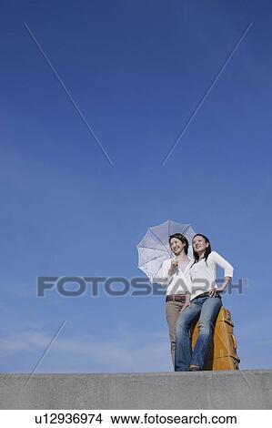 Two young women standing on breakwater View Large Photo Image Picture - Two young women standing on breakwater. Fotosearch