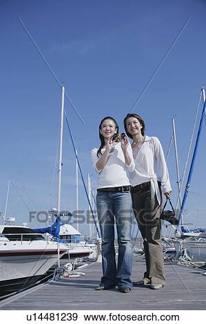 Two young women standing on pier View Large Photo Image Stock Photo - Two young women standing on pier. Fotosearch