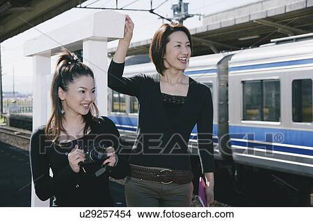 Two young women standing on train platform View Large Photo Image Picture - Two young women standing on train platform. Fotosearch