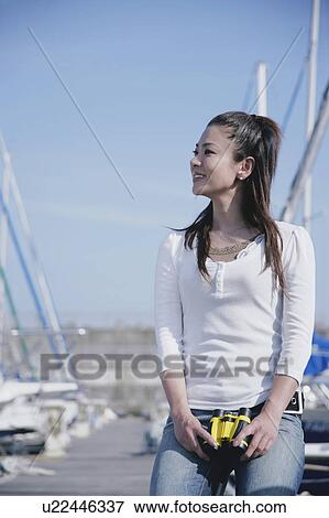 Young woman sitting in marina View Large Photo Image Stock Photo - Young woman sitting in marina. Fotosearch