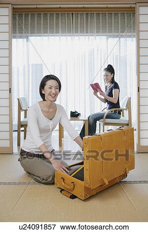 Young woman unpacking suitcase in Japanese style inn View Large Photo Image Stock Photo - Young woman unpacking suitcase in Japanese style inn. Fotosearch