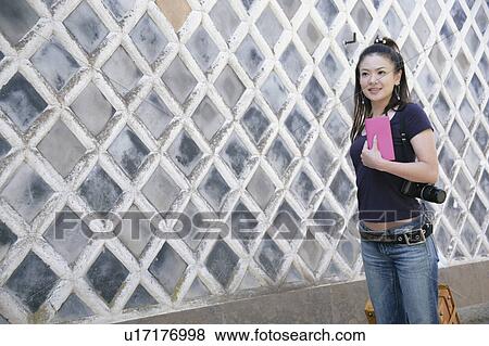 Stock Photo - Young woman walking with suitcase. Fotosearch
