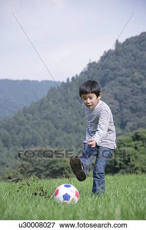 Stock Photo - Boy kicking soccer ball. Fotosearch