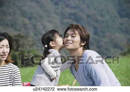Stock Image - Daughter kissing father on cheek. Fotosearch