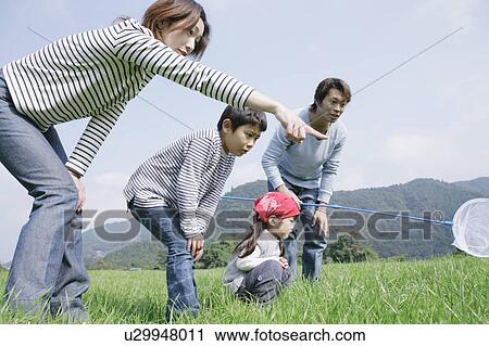 Family catching insects in meadow View Large Photo Image Stock Image - Family catching insects in meadow. Fotosearch
