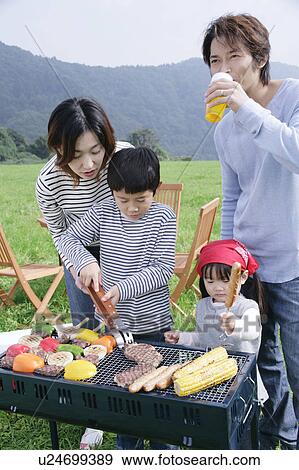 Stock Photo - Family having barbeque. Fotosearch