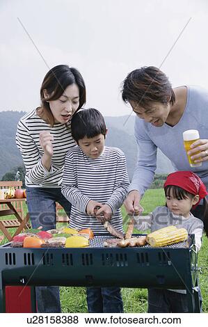 Stock Photo - Family having barbeque. Fotosearch