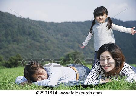 Family lying down on ground View Large Photo Image Picture - Family lying down on ground. Fotosearch