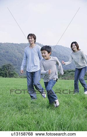 Stock Photo - Family running in meadow. Fotosearch