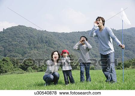 Stock Photo - Family shouting in meadow. Fotosearch
