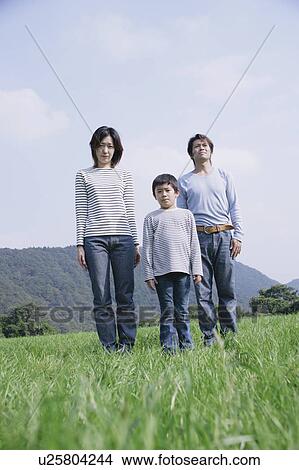 Picture - Family standing in meadow. Fotosearch