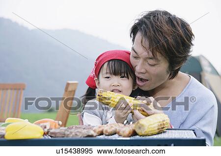 Stock Photography - Father and daughter having barbeque. Fotosearch