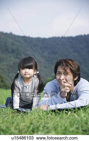 Father and daughter lying down on ground View Large Photo Image Stock Image - Father and daughter lying down on ground. Fotosearch