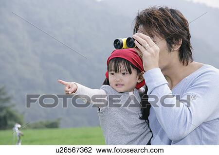 Stock Image - Father and daughter using binoculars. Fotosearch
