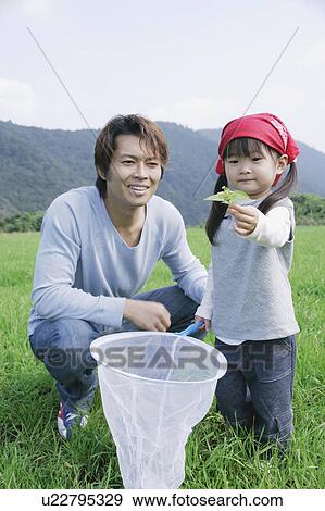 Stock Photo - Father and daughter with butterfly net. Fotosearch
