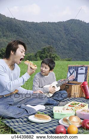Stock Image - Father and son having picnic. Fotosearch