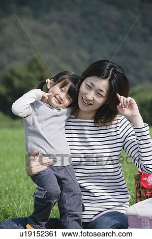 Stock Image - Mother and daughter looking at camera. Fotosearch