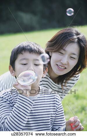 Mother and son blowing bubbles View Large Photo Image Picture - Mother and son blowing bubbles. Fotosearch