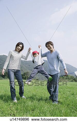 Parents lifting daughter by hands View Large Photo Image Stock Photograph - Parents lifting daughter by hands. Fotosearch