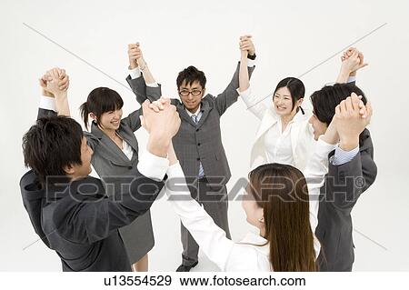 Stock Photo - Business people standing in circle holding hands. Fotosearch