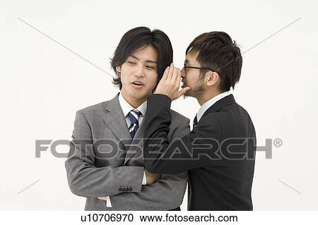 Businessman whispering to his colleague View Large Photo Image Stock Image - Businessman whispering to his colleague. Fotosearch