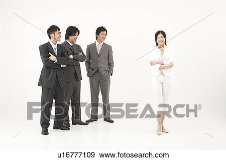 Three businessmen looking at businesswoman View Large Photo Image Stock Photo - Three businessmen looking at businesswoman. Fotosearch