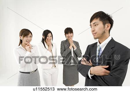 Stock Image - Three businesswomen looking at businessman. Fotosearch