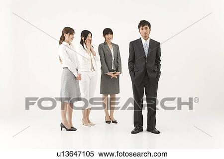 Stock Photography - Three businesswomen looking at businessman. Fotosearch