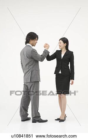 Stock Image - Two business people shaking hands. Fotosearch