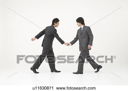 Stock Image - Two businessmen shaking hands. Fotosearch