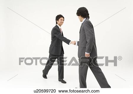 Stock Image - Two businessmen shaking hands. Fotosearch