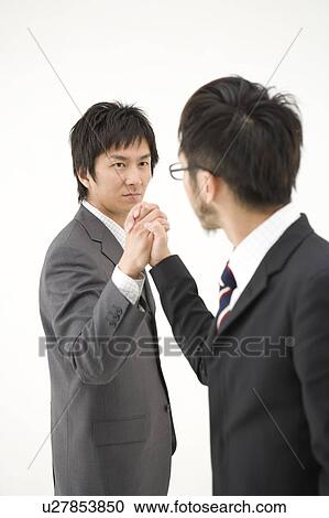 Stock Image - Two businessmen shaking hands. Fotosearch