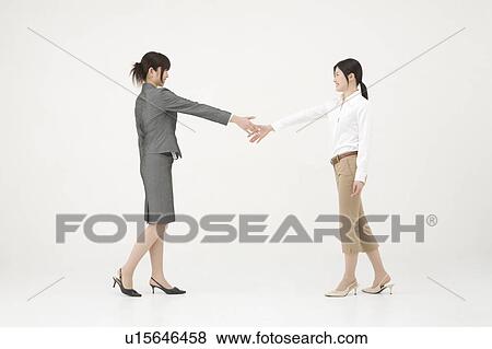 Stock Photo - Two businesswomen shaking hands. Fotosearch