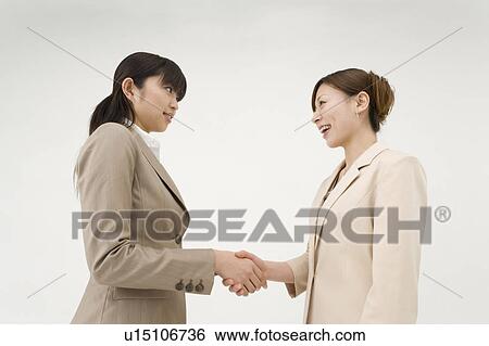 Stock Photograph - Two businesswomen shaking hands. Fotosearch