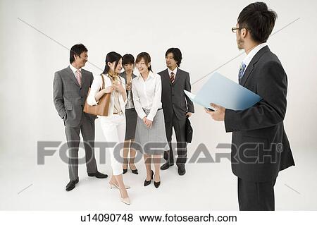 Businessman excluded from group of business people View Large Photo Image Stock Photo - Businessman excluded from group of business people. Fotosearch