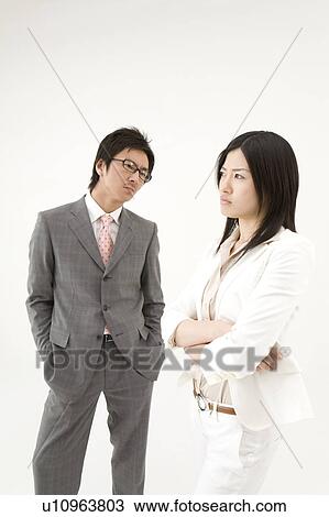 Stock Image - Two business people glaring at each other. Fotosearch