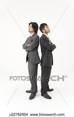 Picture - Two businessmen standing back to back. Fotosearch