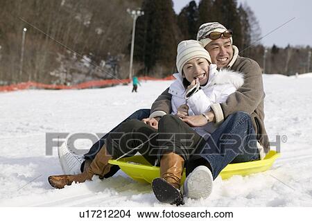 Picture - Young couple sledding. Fotosearch