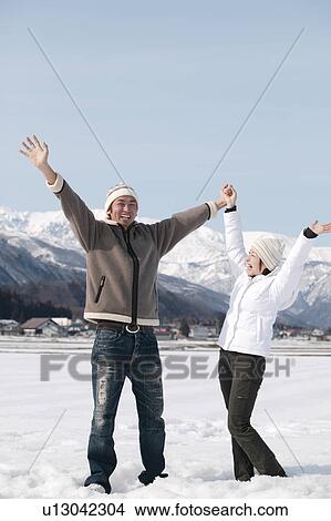 Young couple standing in snow View Large Photo Image Picture - Young couple standing in snow. Fotosearch