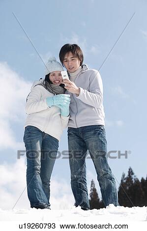 Young couple taking photo with mobile phone View Large Photo Image Stock Image - Young couple taking photo with mobile phone. Fotosearch