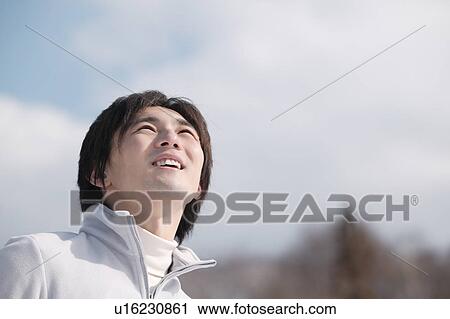 Stock Image - Young man looking up. Fotosearch