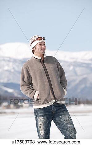 Young man standing in snow View Large Photo Image Stock Photo - Young man standing in snow. Fotosearch