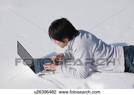 Young man using computer on snow View Large Photo Image Stock Image - Young man using computer on snow. Fotosearch