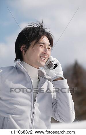 Stock Image - Young man using mobile phone. Fotosearch